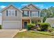 Charming two-story home with a well-maintained lawn, attached garage, and inviting blue door at 207 Diamond Valley Pass, Canton, GA 30114