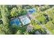 Aerial view of a community with swimming pool, tennis courts, and green spaces nestled among mature trees in a neighborhood setting at 3025 Mountain Creek Ne Ct, Roswell, GA 30075