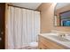 Neutral bathroom features a white shower curtain, sink with wood cabinets and mirror at 3025 Mountain Creek Ne Ct, Roswell, GA 30075