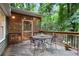 Wooden deck features a patio table and a view into the backyard, with the screened porch to the left at 3025 Mountain Creek Ne Ct, Roswell, GA 30075