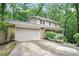 Two-story home featuring a two-car garage and a cozy front porch surrounded by lush landscaping at 3025 Mountain Creek Ne Ct, Roswell, GA 30075