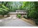 Charming two-story home with a front porch and a spacious driveway surrounded by lush greenery at 3025 Mountain Creek Ne Ct, Roswell, GA 30075