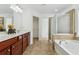 Bright bathroom featuring a tub with tile surround, glass enclosed shower, window, and tile floor at 303 Ridgewood Trl, Canton, GA 30115