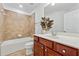 Cozy bathroom featuring a tub with tile surround, toilet, and wooden vanity with neutral countertop at 303 Ridgewood Trl, Canton, GA 30115