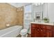 Cozy bathroom featuring a tub with tile surround, window, toilet, and wooden vanity with neutral countertop at 303 Ridgewood Trl, Canton, GA 30115