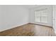 Unfurnished bedroom with natural light, showcasing hardwood floors, window with blinds, and white walls at 303 Ridgewood Trl, Canton, GA 30115
