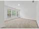 Bright bedroom with neutral carpet, featuring a large window overlooking the outdoors at 303 Ridgewood Trl, Canton, GA 30115