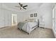 The main bedroom featuring a tray ceiling, carpet, a bed, and windows overlooking the beautiful outdoors at 303 Ridgewood Trl, Canton, GA 30115