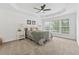 The main bedroom featuring a tray ceiling, carpet, a bed, and windows overlooking the beautiful outdoors at 303 Ridgewood Trl, Canton, GA 30115