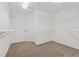 Spacious walk-in closet with carpet flooring, featuring shelving and a door at 303 Ridgewood Trl, Canton, GA 30115