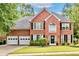 Beautiful two-story brick home with manicured lawn, black shutters, and a two car garage at 3990 Madison Main Nw, Kennesaw, GA 30144