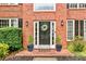 Close-up of the front door showcasing a welcoming wreath, flanking potted plants, and stylish sconces at 3990 Madison Main Nw, Kennesaw, GA 30144