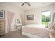 Bedroom with floral bedding, vanity, and view to treed outdoors at 7345 Vale Ct, Cumming, GA 30028