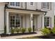 Inviting front porch with elegant columns, stylish lighting, and comfortable seating at 7345 Vale Ct, Cumming, GA 30028