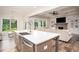 Kitchen island with stainless steel sink overlooks living room featuring fireplace and coffered ceilings at 7345 Vale Ct, Cumming, GA 30028