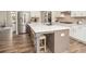Modern kitchen island featuring white countertops, dark wood accents, barstool seating, and stainless steel appliances at 7345 Vale Ct, Cumming, GA 30028