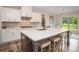 Bright kitchen boasts white cabinets, quartz countertops, gas range, and a large island with seating at 7345 Vale Ct, Cumming, GA 30028
