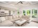 Spacious living room featuring hardwood floors, a comfortable sectional sofa, and a seamless transition to the kitchen at 7345 Vale Ct, Cumming, GA 30028