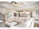 Open-concept living room with coffered ceilings, hardwood floors, comfortable sectional sofa, and seamless transition to kitchen at 7345 Vale Ct, Cumming, GA 30028