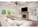 Bright living room with coffered ceilings, brick fireplace, built-in shelves, and a comfortable oversized sectional sofa at 7345 Vale Ct, Cumming, GA 30028