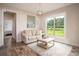 Sitting room with a comfortable sofa and a view of the landscaped outdoors at 7345 Vale Ct, Cumming, GA 30028