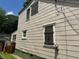 Side view of the home featuring vinyl siding, various windows, and a partly green foundation at 1785 S Olympian Sw Way, Atlanta, GA 30310