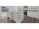 Modern kitchen featuring a kitchen island with seating, stainless steel appliances, and hardwood flooring at 412 Corricella Ct, Mcdonough, GA 30253