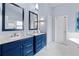 Stylish bathroom with double vanity, blue cabinets, and a white tiled floor at 648 York View Dr, Auburn, GA 30011