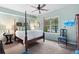 Well-lit bedroom with large bed, ceiling fan, poolside views from the window and a sitting area at 648 York View Dr, Auburn, GA 30011