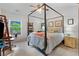 Bedroom with a four poster bed, soft gray walls, and bright window with view of the trees and sunlight at 648 York View Dr, Auburn, GA 30011