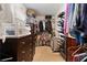 Spacious walk-in closet with shelving, hanging storage, shoe racks and dark wood dresser and plenty of storage space at 648 York View Dr, Auburn, GA 30011