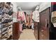 Organized walk-in closet featuring shelving, shoe racks, hanging rods, and dark wood dressers for ample storage at 648 York View Dr, Auburn, GA 30011