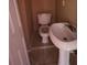 Small bathroom with a toilet and pedestal sink, featuring neutral-toned walls at 352 Price Rd, Carrollton, GA 30116