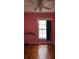 Pink bedroom featuring hardwood floors, a ceiling fan, and a window with blue curtains at 352 Price Rd, Carrollton, GA 30116