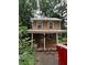 Rustic two-story home with a covered porch and metal roof nestled in a wooded lot at 352 Price Rd, Carrollton, GA 30116