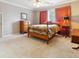 Cozy bedroom with wood furniture, plush carpet, and bright orange window treatments at 3616 Blakeford Ct, Marietta, GA 30062