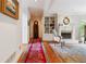 Inviting hallway with hardwood floors, a decorative rug, and a view of the fireplace and built-in bookcase at 3616 Blakeford Ct, Marietta, GA 30062