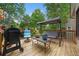 Relaxing back deck with a grill, furniture, lush greenery, and an outdoor seating area at 404 Pine Grove Way, Woodstock, GA 30189