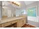 Bathroom featuring double sinks, a garden tub, and granite counters at 404 Pine Grove Way, Woodstock, GA 30189