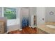 Bathroom featuring a garden tub, granite counters, and a privacy window at 404 Pine Grove Way, Woodstock, GA 30189