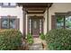 Charming front door with leaded glass sidelights and is framed by manicured landscaping at 404 Pine Grove Way, Woodstock, GA 30189