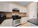 Well-appointed kitchen with stainless steel oven and microwave, granite countertops, and decorative tile backsplash at 404 Pine Grove Way, Woodstock, GA 30189