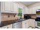 Modern kitchen featuring granite counters, stainless steel appliances, tile backsplash, and ample storage at 404 Pine Grove Way, Woodstock, GA 30189