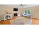 Cozy living room featuring a decorative fireplace, a ceiling fan, and hardwood floors at 404 Pine Grove Way, Woodstock, GA 30189