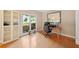 Well-lit office with large window view, hardwood floors, built-in shelving, and a comfortable workspace at 404 Pine Grove Way, Woodstock, GA 30189
