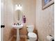 Charming powder room featuring decorative wallpaper, a pedestal sink, and classic fixtures at 404 Pine Grove Way, Woodstock, GA 30189