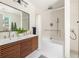 Stylish bathroom featuring a double vanity with sleek wood cabinets, modern fixtures, and a separate tub with shower at 124 Richmond Se St, Atlanta, GA 30312