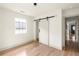 Bright bedroom with hardwood floors, large window, closet with sliding door, and neutral color scheme at 124 Richmond Se St, Atlanta, GA 30312
