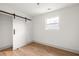 Bright bedroom with hardwood floors, large window, closet with sliding door, and neutral color scheme at 124 Richmond Se St, Atlanta, GA 30312