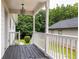 Covered porch with decorative pillars and ample space for outdoor seating, with lush greenery in the background at 124 Richmond Se St, Atlanta, GA 30312